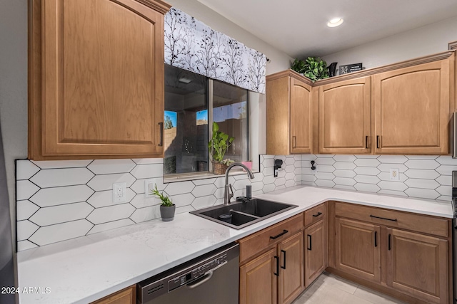 kitchen with decorative backsplash, dishwasher, sink, and light stone counters