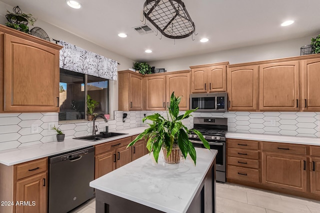 kitchen with sink, a center island, stainless steel appliances, decorative backsplash, and light tile patterned floors