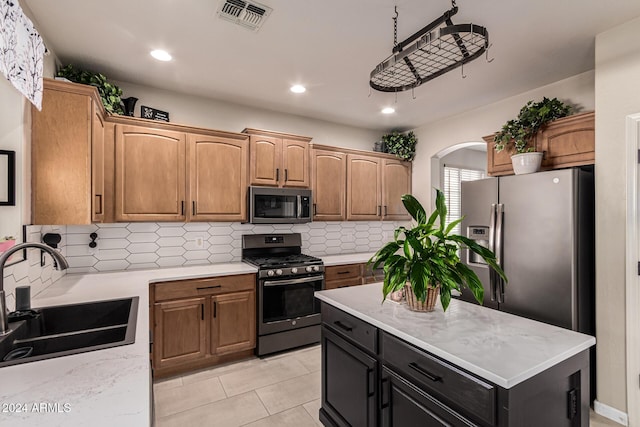 kitchen featuring light stone countertops, sink, stainless steel appliances, decorative backsplash, and light tile patterned floors