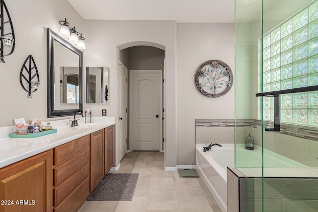 bathroom with tile patterned flooring, vanity, and plus walk in shower