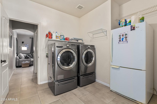 washroom featuring washer and clothes dryer and light tile patterned floors