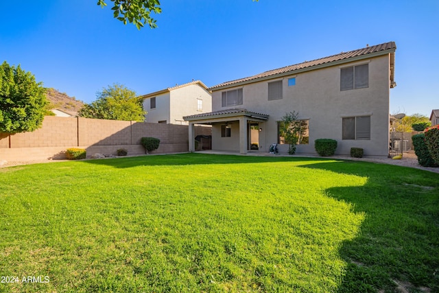 rear view of property featuring a lawn