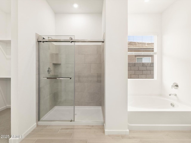 bathroom featuring shower with separate bathtub