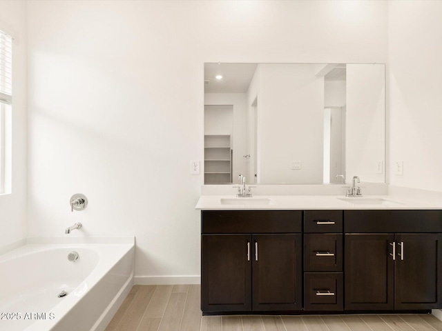 bathroom with vanity, wood-type flooring, and a bathtub