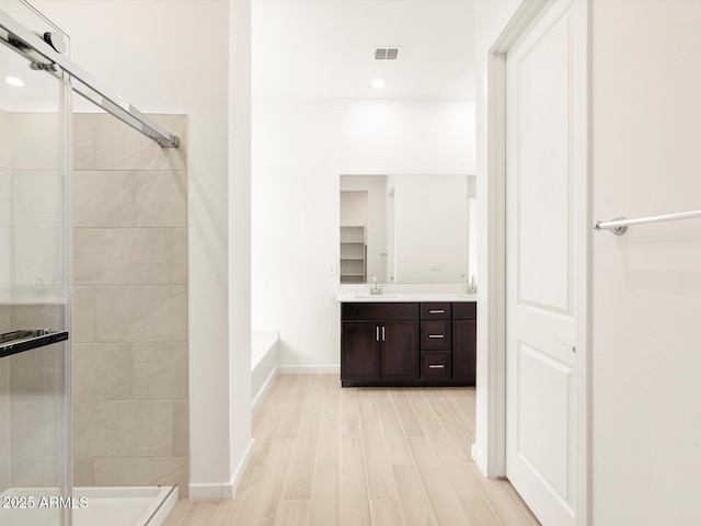 bathroom featuring independent shower and bath, vanity, and hardwood / wood-style flooring