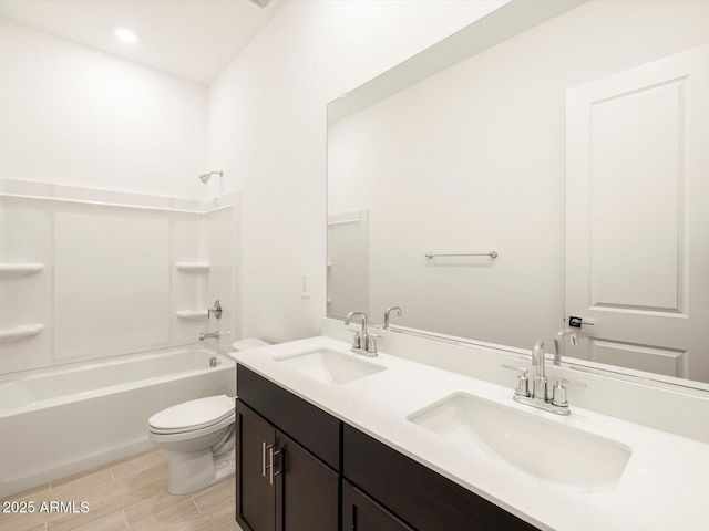 full bathroom featuring vanity, washtub / shower combination, and toilet