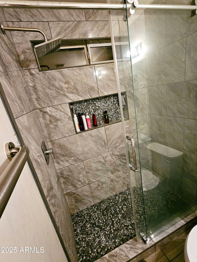 full bathroom with a stall shower and toilet