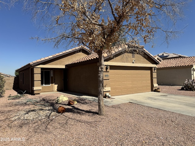 view of front of property featuring a tile roof, stucco siding, concrete driveway, and a garage