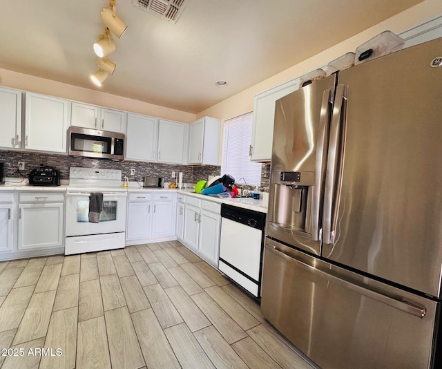 kitchen with stainless steel appliances, backsplash, visible vents, and light countertops