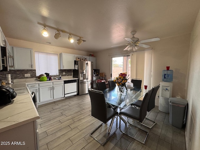 dining area featuring a ceiling fan and wood tiled floor