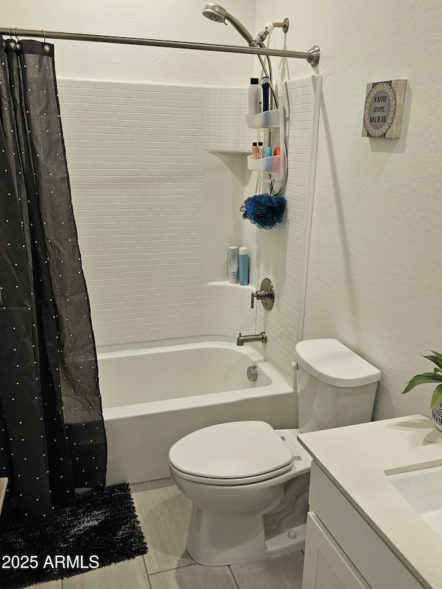 full bath with a textured wall, vanity, shower / bath combination with curtain, and toilet