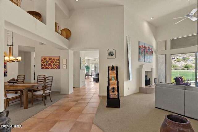 9432 N Longfeather, Fountain Hills, AZ 85268 - living area with a high ceiling, a ceiling fan, baseboards, a chandelier, and a tiled fireplace