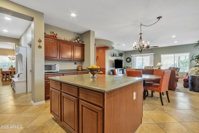 kitchen featuring a chandelier, a center island, open floor plan, and pendant lighting