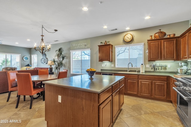 kitchen featuring recessed lighting, a kitchen island, a sink, visible vents, and stainless steel range