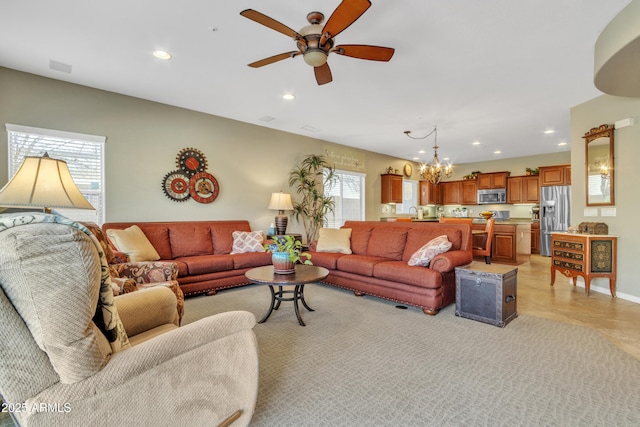 living area with ceiling fan with notable chandelier, visible vents, and recessed lighting