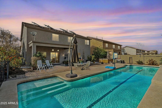 back of house featuring a fenced in pool, a patio area, fence, and stucco siding