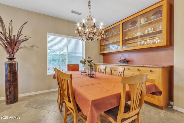 dining space with visible vents, a notable chandelier, and baseboards