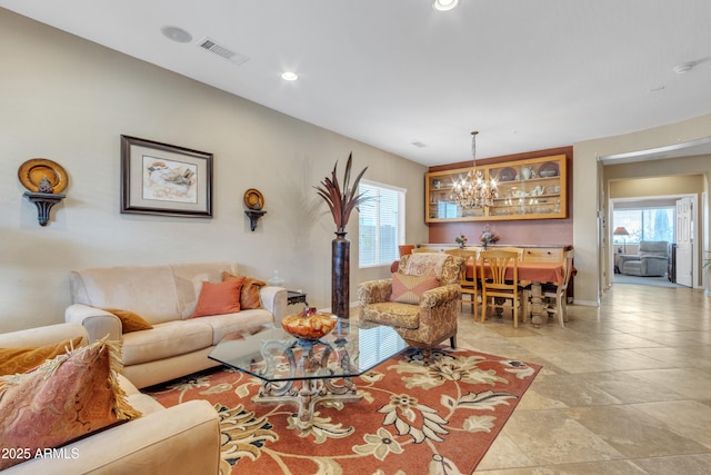 living area with a chandelier, plenty of natural light, visible vents, and recessed lighting