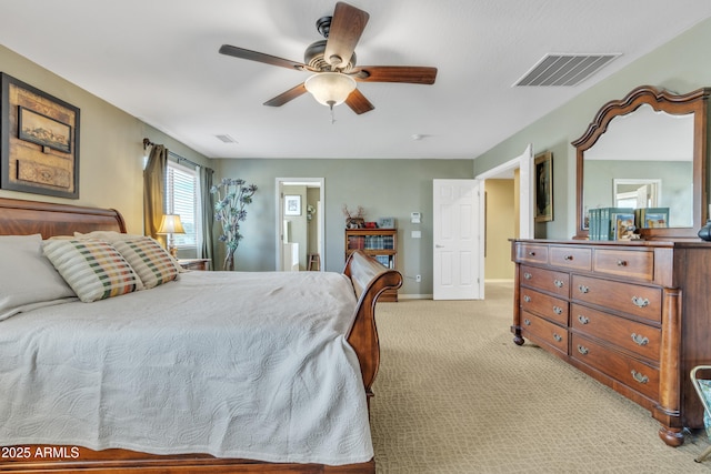 bedroom featuring light colored carpet, visible vents, ensuite bathroom, a ceiling fan, and baseboards