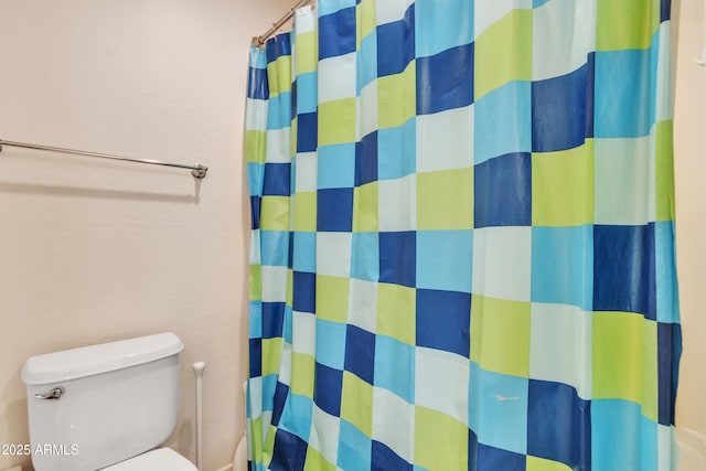 bathroom featuring toilet and a shower with shower curtain