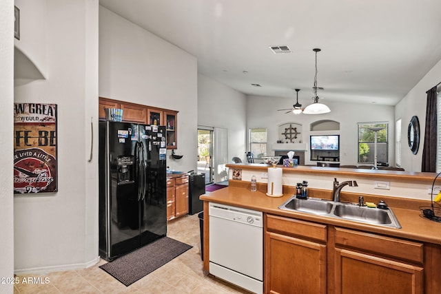 18057 W Port Royale Ln, Surprise, AZ 85388 - kitchen with a sink, black fridge, brown cabinets, white dishwasher, and visible vents