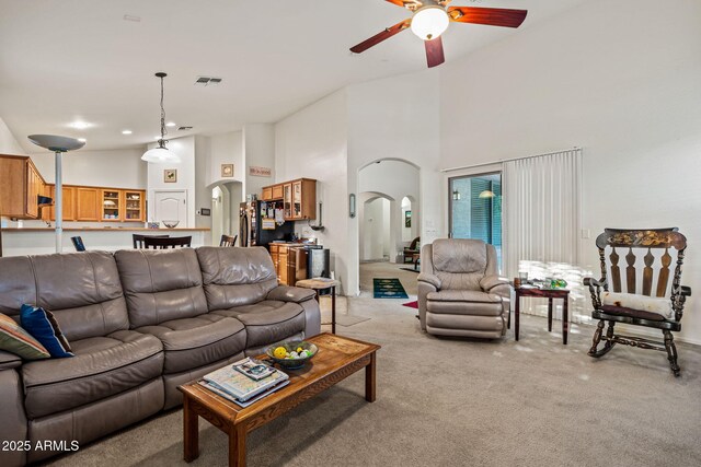 18057 W Port Royale Ln, Surprise, AZ 85388 - living room featuring high vaulted ceiling, a ceiling fan, light carpet, visible vents, and arched walkways