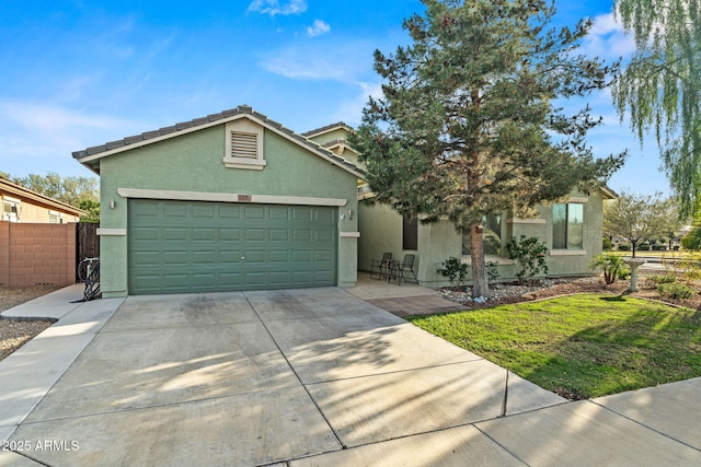 18057 W Port Royale Ln, Surprise, AZ 85388 - view of front of home featuring a garage, concrete driveway, stucco siding, and fence