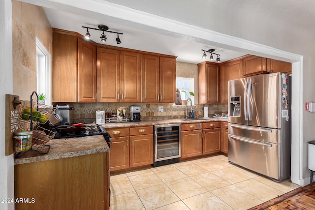 kitchen featuring wine cooler, track lighting, sink, light tile patterned floors, and stainless steel fridge