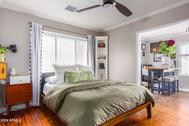 bedroom with ornamental molding, hardwood / wood-style flooring, and ceiling fan