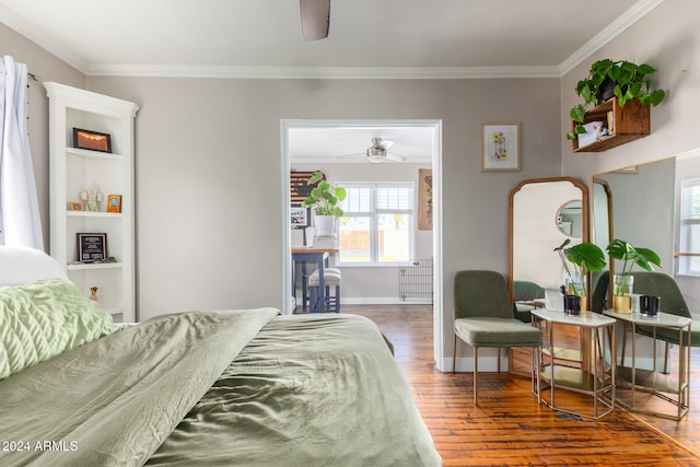 bedroom with dark wood-type flooring, ceiling fan, and crown molding