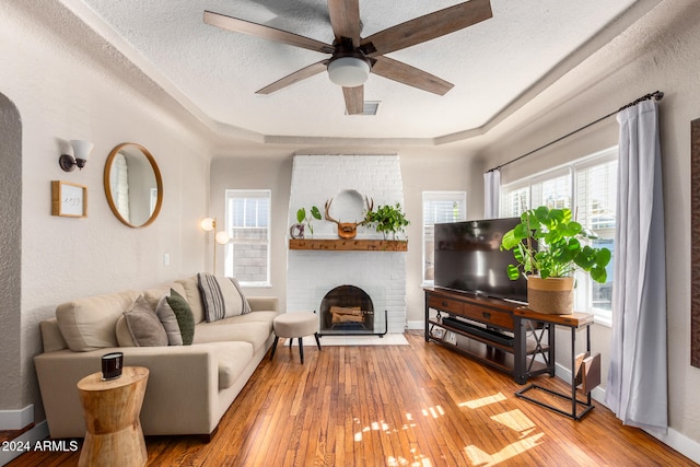 living room featuring a textured ceiling, wood-type flooring, and plenty of natural light