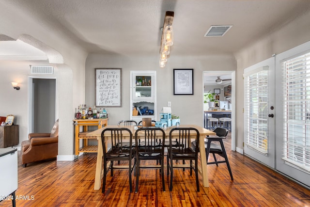 dining space with hardwood / wood-style flooring, ceiling fan, a textured ceiling, and french doors