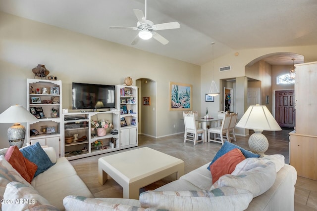 living room featuring lofted ceiling and ceiling fan with notable chandelier