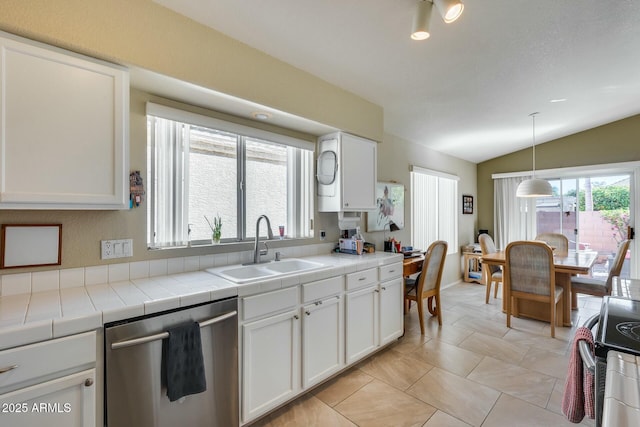 kitchen featuring white cabinets, tile counters, vaulted ceiling, and appliances with stainless steel finishes