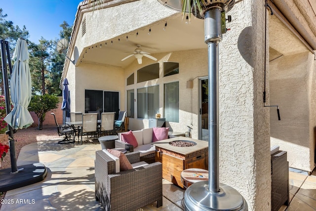 view of patio / terrace with an outdoor living space with a fire pit and ceiling fan