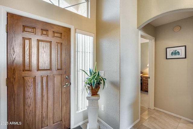 foyer entrance with a wealth of natural light and light tile patterned flooring