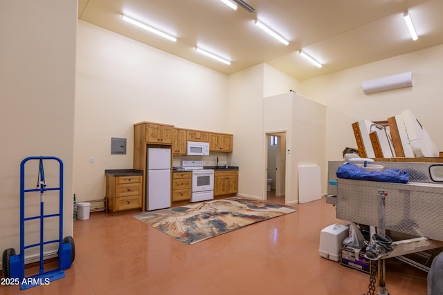 interior space featuring a towering ceiling, concrete floors, and a wall mounted air conditioner