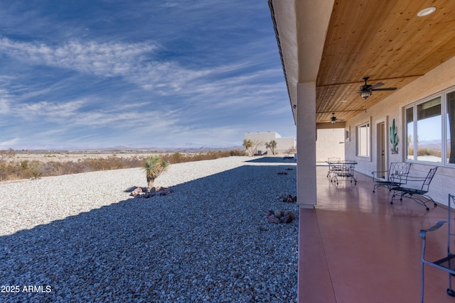 view of yard with ceiling fan and a patio area