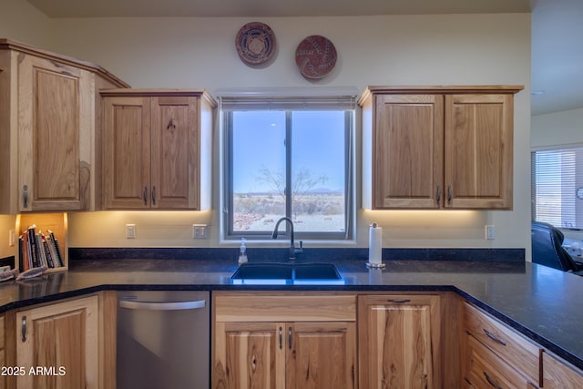 kitchen with stainless steel dishwasher, plenty of natural light, dark stone counters, and sink