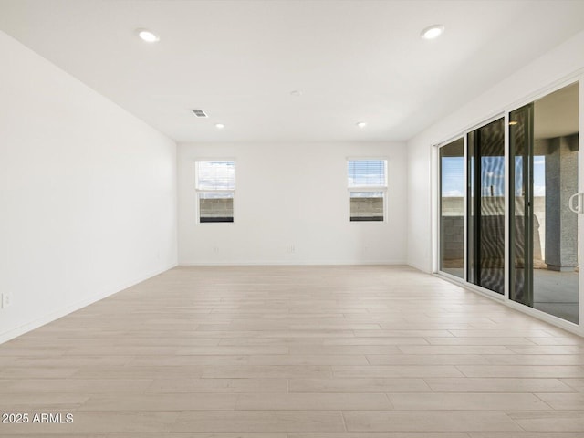 empty room featuring recessed lighting, light wood-style flooring, baseboards, and visible vents
