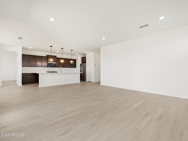 unfurnished living room featuring recessed lighting and light wood-style flooring