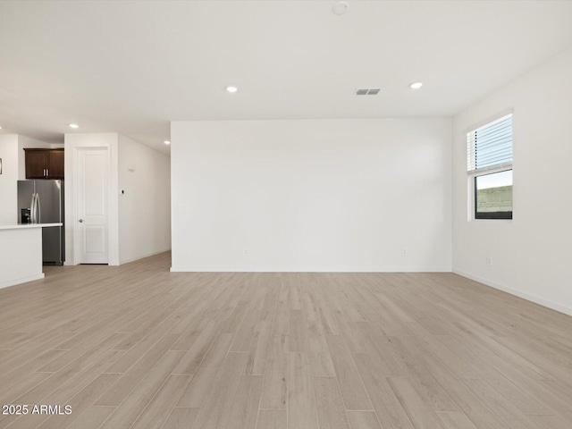 unfurnished living room with visible vents, baseboards, recessed lighting, and light wood-style floors