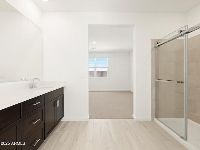 full bath featuring vanity, a stall shower, and wood finished floors