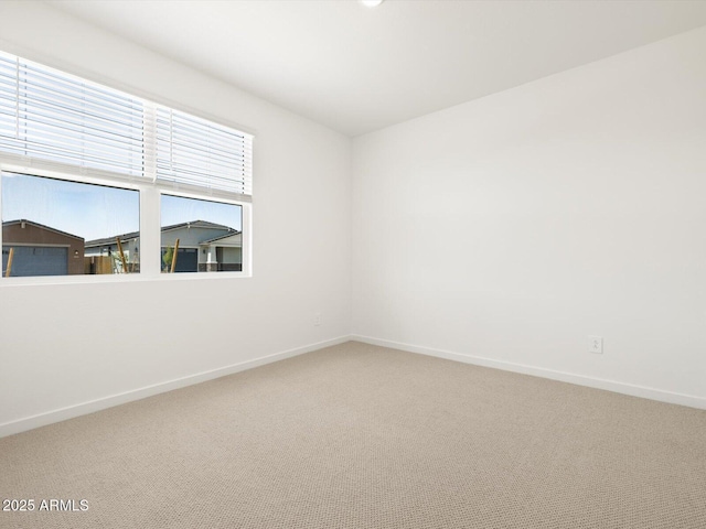 carpeted empty room with baseboards