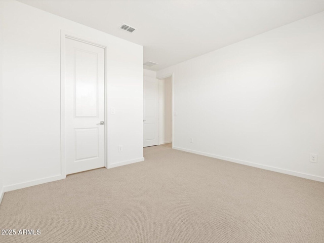 unfurnished room with visible vents, baseboards, and light colored carpet