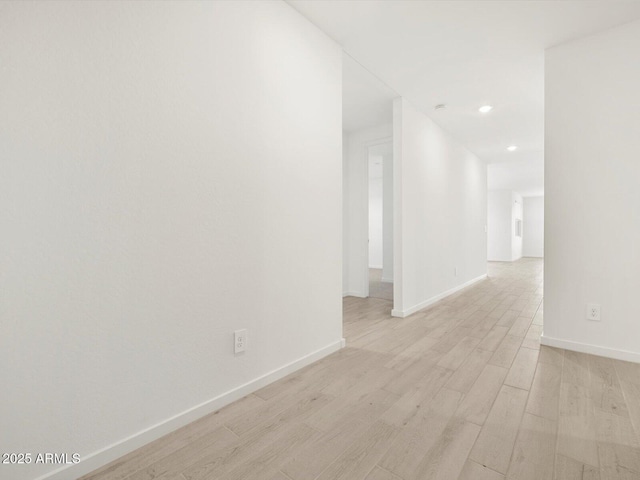 empty room featuring recessed lighting, light wood-style flooring, and baseboards