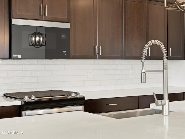 kitchen featuring tasteful backsplash, appliances with stainless steel finishes, light countertops, and dark brown cabinetry