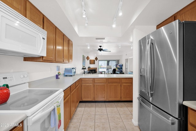 8651 E Royal Palm Rd Unit 121, Scottsdale, AZ 85258 - kitchen with white appliances, rail lighting, light countertops, light tile patterned flooring, and brown cabinetry