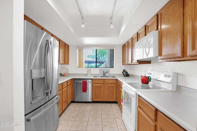 8651 E Royal Palm Rd Unit 121, Scottsdale, AZ 85258 - kitchen with appliances with stainless steel finishes, a tray ceiling, light tile patterned flooring, rail lighting, and light countertops