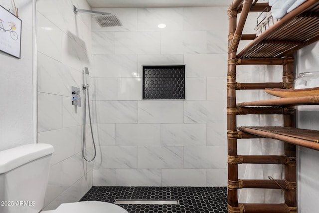 bathroom featuring toilet and tiled shower